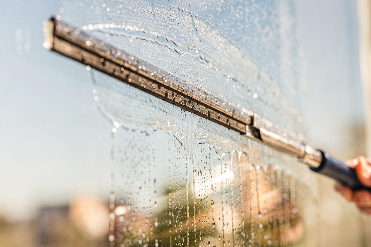 A squeegee drawing a clean, streak-free path across wet glass